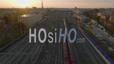 Forwards Tracking Of Passenger Train Unit Heading To Central Train Station, Passing By Next Train Moving Reverse Direction. Aerial View Against Sunset. Rome, Italy - Video Drone Footage
