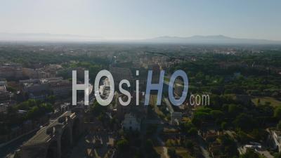 Aerial Slide And Pan Footage Of Monumental Ancient Colosseum Amphitheatre And Surrounding Buildings And Park In City. Rome, Italy - Video Drone Footage