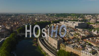 Aerial Cinematic Footage Of Tiber River Bend And Buildings On Waterfront. River Lined By Rows Of Green Trees. Rome, Italy - Video Drone Footage