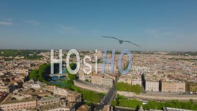 Aerial Cinematic Footage Of Old Buildings In City. Green Trees Along Tiber River Bending Around Centre. Rome, Italy - Video Drone Footage