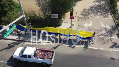 2022 - Aerial Ukrainian Antiwar Protesters Display A Long Flag And Signs On Pacific Coast Highway - Video Drone Footage