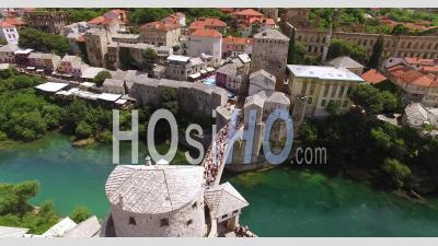 An Aerial View Shows Crowds Assembled On The Mostar Bridge And The Neretva River It Passes Over In Mostar, Bosnia - Video Drone Footage