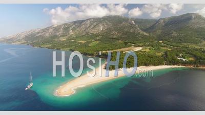 An Aerial View Shows Zlatni Rat Beach And Its Surrounding Mountains On Brac Island, Croatia - Video Drone Footage