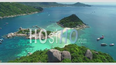An Aerial View Shows Tourists Walking Along A Beach On Ko Tao, Thailand - Video Drone Footage