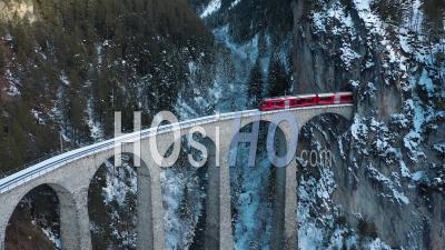 2022 - Excellent Aerial View Of A Train Coming Out Of The Landwasser Viaduct In Switzerland - Video Drone Footage