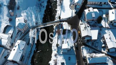 2022 - Excellent Overhead View Of Cars Driving Through The Wintry Town Of Susch, Switzerland - Video Drone Footage
