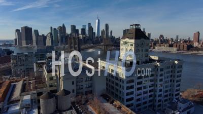 Excellent Aerial Of Dumbo Brooklyn Apartments With Brooklyn Bridge, East River And New York City Skyline In Distance - Video Drone Footage