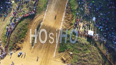 Aerial Of Motorcycle Rider On Vertical Dirt Incline Track At Motocross Event Travels Uphill To Finish Line - Video Drone Footage