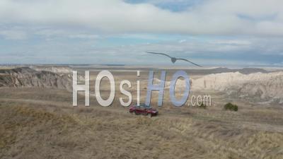 Car Driving Along Edge Of Canyon, The Badlands, South Dakota, Usa - Video Drone Footage