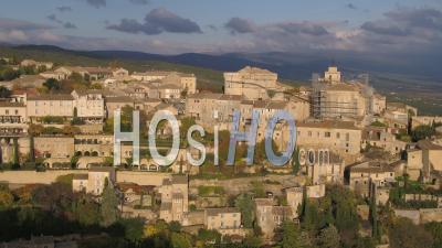 Village Of Gordes Perched On A Rocky Spur Dominated By Its Renaissance Castle And Its Romanesque Church Of Saint-Firmin, Vaucluse, France - Video Drone Footage