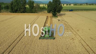 Combine Harvester In Wheat Field In A Plain In The French Alps, France, Drone Point Of View