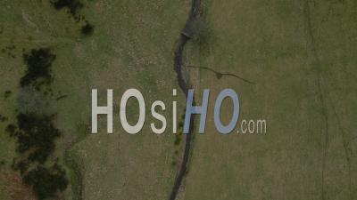 Une Rivière Serpentant À Travers Les Champs Des Highlands Écossais Avec Des Montagnes Enneigées En Arrière-Plan - Vidéo Par Drone