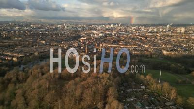 Queens Park And A Rainbow During A Spring Afternoon With Tenement Housing, The City Centre And The Campsies Mountains In The Background - Video Drone Footage
