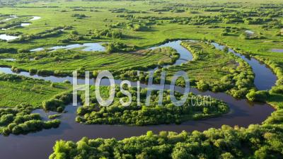 Aerial View Of Winding River Bed With Ducts. Flying Above Swampy Plain. - Video Drone Footage